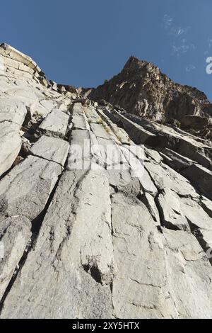 Ampia vista su un pendio roccioso in una giornata estiva soleggiata. Scogliere esagonali strutturali nel Caucaso settentrionale Foto Stock