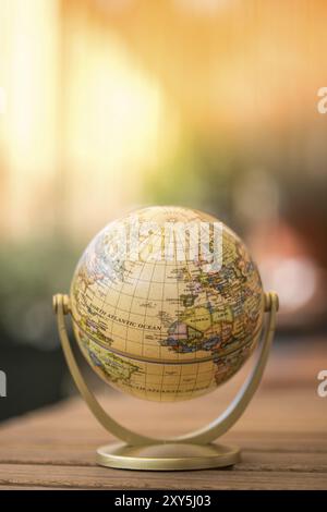 Pianificazione del viaggio successivo: globo in miniatura su un tavolo rustico Foto Stock