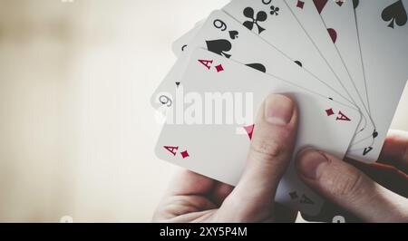 Giovane uomo è giocando a carte, spaccato di sue mani Foto Stock