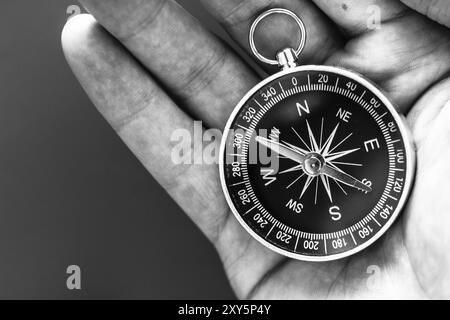 Primo piano di un mans mano che tiene una bussola nella sua mano. Concetto per il business, per l'innovazione Foto Stock