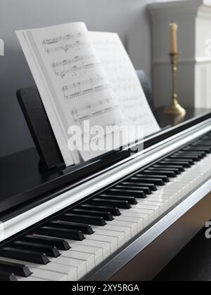 Pianoforte digitale tastiera con spartiti in un salotto interno Foto Stock