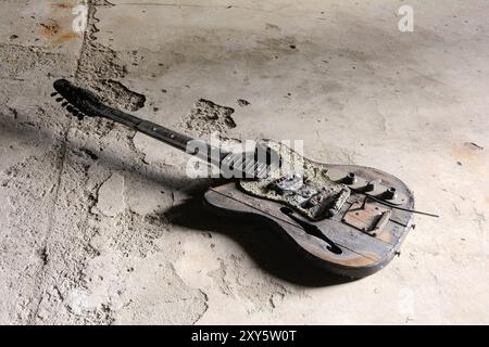 Chitarra bruciata sul pavimento di una casa abbandonata in rovina a Magdeburgo Foto Stock