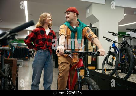 Fidanzato che acquista una bicicletta per una ragazza amorevole al negozio di biciclette sportive Foto Stock