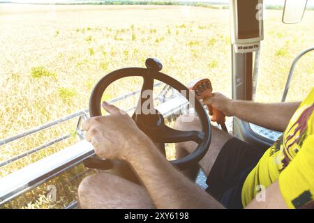 Vista dalla cabina di una mietitrebbia e dal responsabile dell'azienda agricola della mietitrebbia Foto Stock