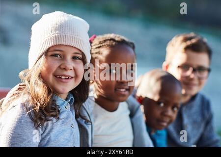 Bambini, ritratti e lezioni all'aperto, studenti e pause per lo sviluppo dell'apprendimento. Bambini, relax e gruppo insieme per una conoscenza elementare Foto Stock