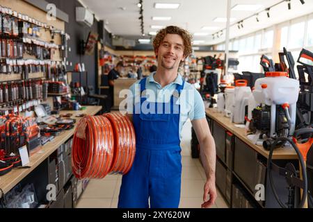 Uomo che acquista attrezzature sostituibili per tubi per innaffiare presso un negozio di ferramenta Foto Stock