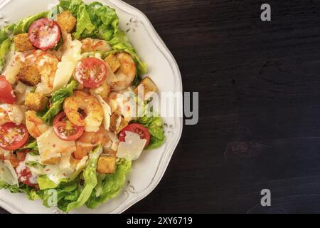 Gamberetti insalata Caesar con formaggio parmigiano, crostini, pomodorini e lattuga, close-up shot di overhead con spazio di copia Foto Stock