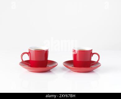 Due rosse piccole tazzine per il caffè isolato su sfondo bianco Foto Stock