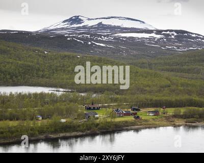 Tana o Tanaelva, vista di un piccolo insediamento sul fiume in Norvegia, che forma il confine tra la Lapponia finlandese settentrionale e la Norvegia, maggio, Fi Foto Stock