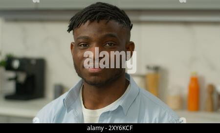 Ritratto felice sorridente afro-americano affittuario amichevole padrone di casa in cucina moderna mattina colazione consegna cibo sorriso birazziale maschio Foto Stock