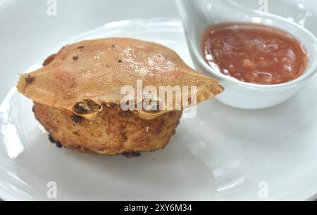 Purè di granchio fritto in profondità e ripieno di maiale in conchiglia di cibo cinese su piatto con salsa piccante al peperoncino Foto Stock