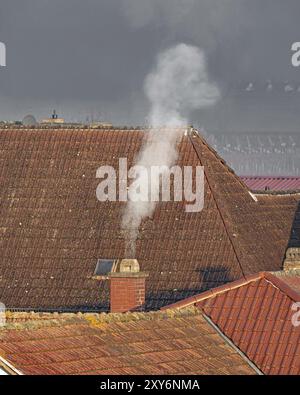 Tetti di un vecchio villaggio con camino fumante e spazio per testo libero Foto Stock