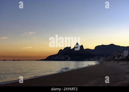 Estate tramonto a Ipanema beach in Rio de Janeiro con due fratelli hill e pietra Gavea in background Foto Stock