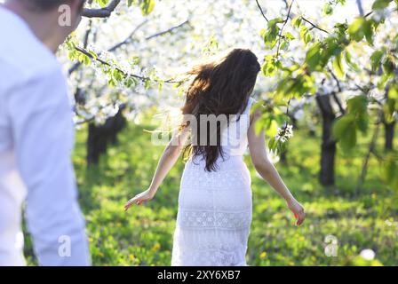 Coppia giovane in amore acceso in primavera sbocciano i fiori del giardino. La felicità e il concetto di amore Foto Stock