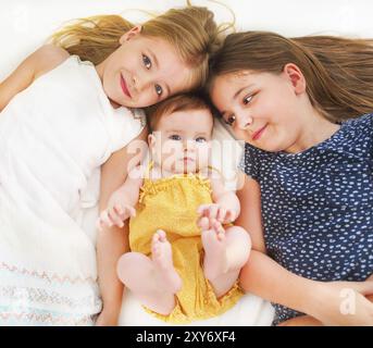 Tre ragazze carine sul letto guardano il ritratto Foto Stock