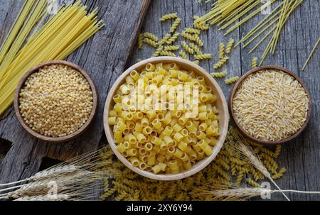 Pasta cruda varia con tagliere su fondo in pietra, concetto di cibo crudo Foto Stock