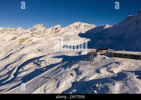 Zermatt, Svizzera: Veduta aerea della famosa stazione sciistica di Zermatt con seggiovia e sciatori e snowboarder sulla pista del Gornergrat Ridge i Foto Stock
