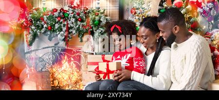 Adorabili poco ragazza afro ricevute regalo di Natale da i suoi genitori Foto Stock