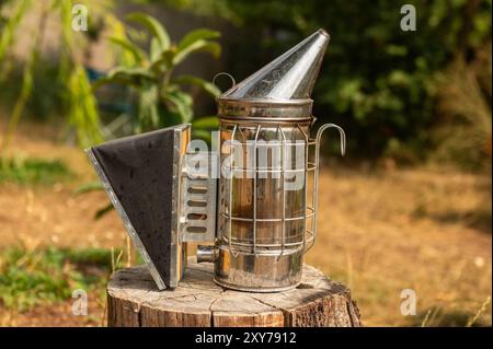 Forniture per l'apicoltura, Bee Hive Smoker sugli alveari. Il processo di estrazione del miele dall'alveare. Attrezzature per apicoltori con fumo per la rimozione b Foto Stock