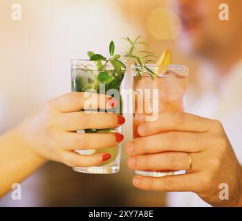 Due bicchieri da cocktail nell uomo e nella donna la mano. Close up Foto Stock