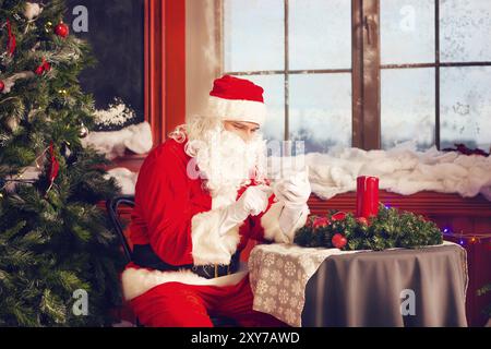Ritratto di una Santa Claus utilizzando uno smart phone Foto Stock