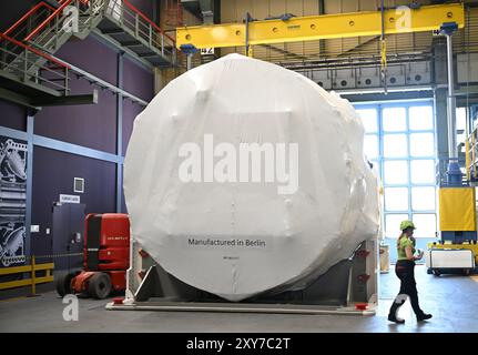 Un dipendente passa davanti a una turbina a gas coperta presso l'impianto Siemens Energy, parte del conglomerato industriale tedesco Siemens, a Berlino, durante la sua visita in Germania e Francia. Data foto: Mercoledì 28 agosto 2024. Foto Stock