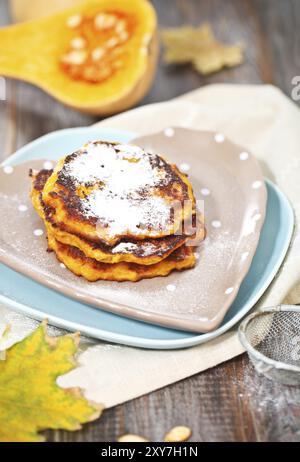 Frittelle di zucca e zucca sullo sfondo di legno Foto Stock