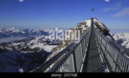 Scena invernale nelle Alpi svizzere. Ponte sospeso che collega due cime montuose a 3000 metri di altitudine. Vista dalla zona sciistica del Glacier de Diablerets Foto Stock