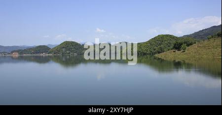 Splendida vista da Majhjkuna, piccolo vollage vicino a Pokhara, Nepal. Colline coperte da foresta che si riflettono nel lago Begnas Foto Stock