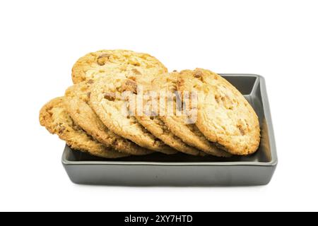 Il cioccolato al latte di mandorla i cookie nella piastra nera su sfondo bianco Foto Stock