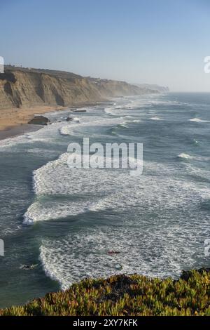 Spiaggia di Magoito con surfisti che navigano sulle onde del mare a Sintra, Portogallo, Europa Foto Stock