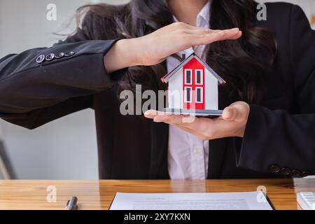 I concessionari immobiliari stanno introducendo modelli per la casa per aiutare i clienti a prendere decisioni di acquisto e firmare gli acquisti, nonché l'assicurazione per la casa e la proprietà Foto Stock