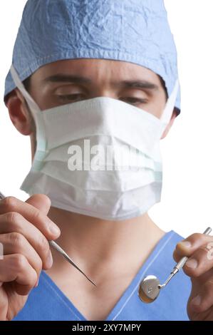 Primo piano di un dentista mani circa per eseguire un intervento su un paziente, isolato in bianco Foto Stock