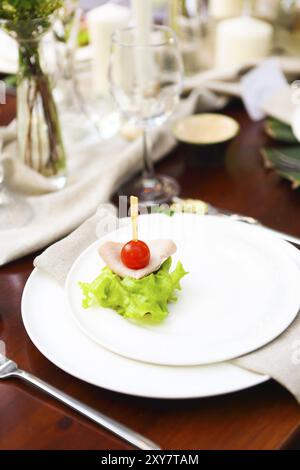 La decorazione della tavola di nozze con vasi di cristallo, fiori e antipasti in stile botanico nel giardino Foto Stock