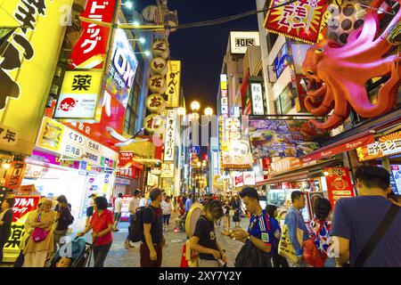 OSAKA, GIAPPONE, 23 GIUGNO 2015: I turisti camminano per la strada pedonale della galleria di Dotonbori sotto l'iconico polpo sovradimensionato e la luce notturna Foto Stock