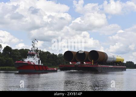 Tugboat che tira parti di una turbina eolica offshore attraverso il canale Kiel, Kielkanal, Schleswig-Holstein, Germania, Europa Foto Stock