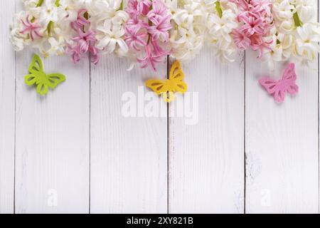 Sfondo primaverile con farfalle colorate, fiori di Giacinto su lavagna di legno bianca con spazio per copiare Foto Stock