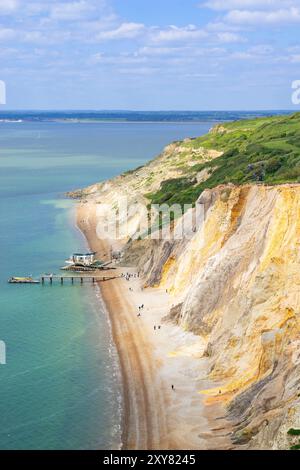 Isola di Wight Regno Unito - Alum Bay persone sulla spiaggia e scogliere di sabbia multicolore presso The Needles Landmark Attraction Isola di Wight Inghilterra Regno Unito Europa Foto Stock