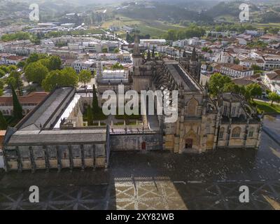 Vista aerea di un monastero storico in architettura gotica, circondato da edifici e natura in un paesaggio verde, vista aerea, monastero e Mosteiro Foto Stock