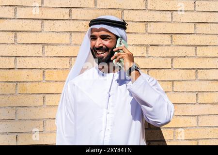 Ritratto di un bell'uomo d'affari arabo che indossa la tradizionale kandura degli emirati - uomo adulto mediorientale con disdasha Foto Stock