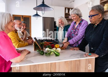 Gruppo di amici anziani felici che si uniscono a casa per la cena - allegri e giovani anziani maturi multietnici che si divertono Foto Stock