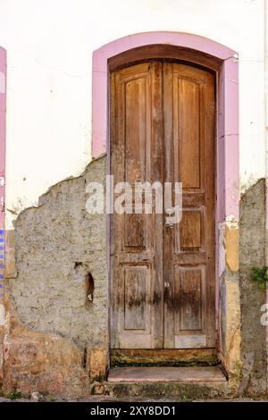 Vecchia porta di legno in stile coloniale mansion deteriorato da tempo con parete danneggiata e vernice pelata Foto Stock