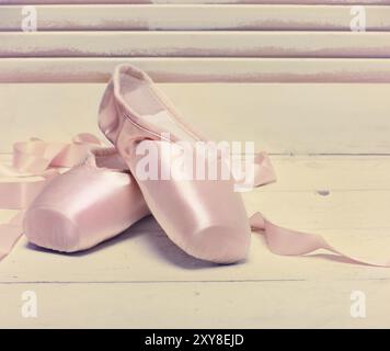 Coppia di un rosa pallido punto di balletto scarpe o pantofole su uno sfondo bianco con spazio di copia Foto Stock