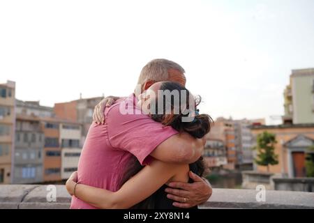 Un padre e una figlia single che si abbracciano per strada. Famiglia felice Foto Stock