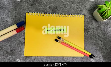 Concetto di Myth Busting scrivere su appiccicose note isolate su un tavolo in legno. Foto Stock