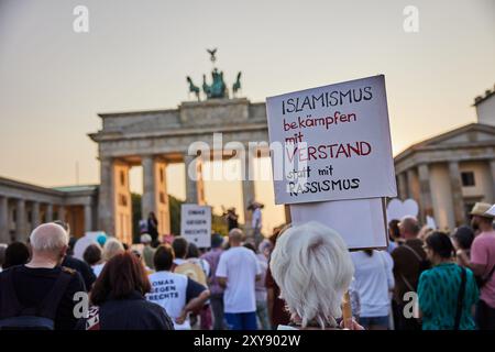 28 agosto 2024, Berlino: "Combattere l'islamismo con la comprensione invece del razzismo”, legge il manifesto di un manifestante durante una manifestazione commemorativa per le vittime a Solingen con il motto "combattere l'islamismo, difendere il diritto di asilo” davanti alla porta di Brandeburgo. L'iniziativa "Herz statt Hetze” (cuore non agitazione) vuole commemorare le vittime dell'attentato di Solingen e prende in esame in modo critico la controversia in corso sul diritto di asilo. L'iniziativa è sostenuta da persone impegnate per la democrazia a LeaveNoOneBehind e Zusammen Gegen Rechts. Foto: Joerg Carstensen/d Foto Stock