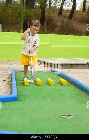 Bambini che giocano a minigolf la sera d'estate sul territorio dell'hotel Foto Stock