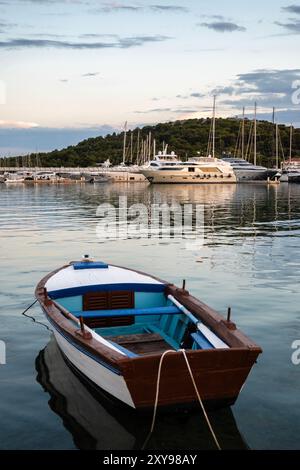 Rogoznica, Croazia - 24 giugno 2024: Vecchio peschereccio in legno ancorato nel porticciolo di Rogoznica, Croazia, di fronte a moderni yacht e barche a vela Foto Stock