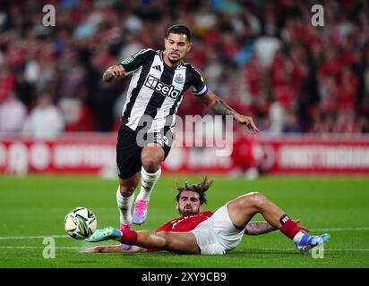 Bruno Guimaraes del Newcastle United in azione contro Jota Silva del Nottingham Forest durante la partita del secondo turno della Carabao Cup al City Ground di Nottingham. Data foto: Mercoledì 28 agosto 2024. Foto Stock