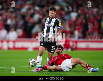 Bruno Guimaraes del Newcastle United in azione contro Jota Silva del Nottingham Forest durante la partita del secondo turno della Carabao Cup al City Ground di Nottingham. Data foto: Mercoledì 28 agosto 2024. Foto Stock